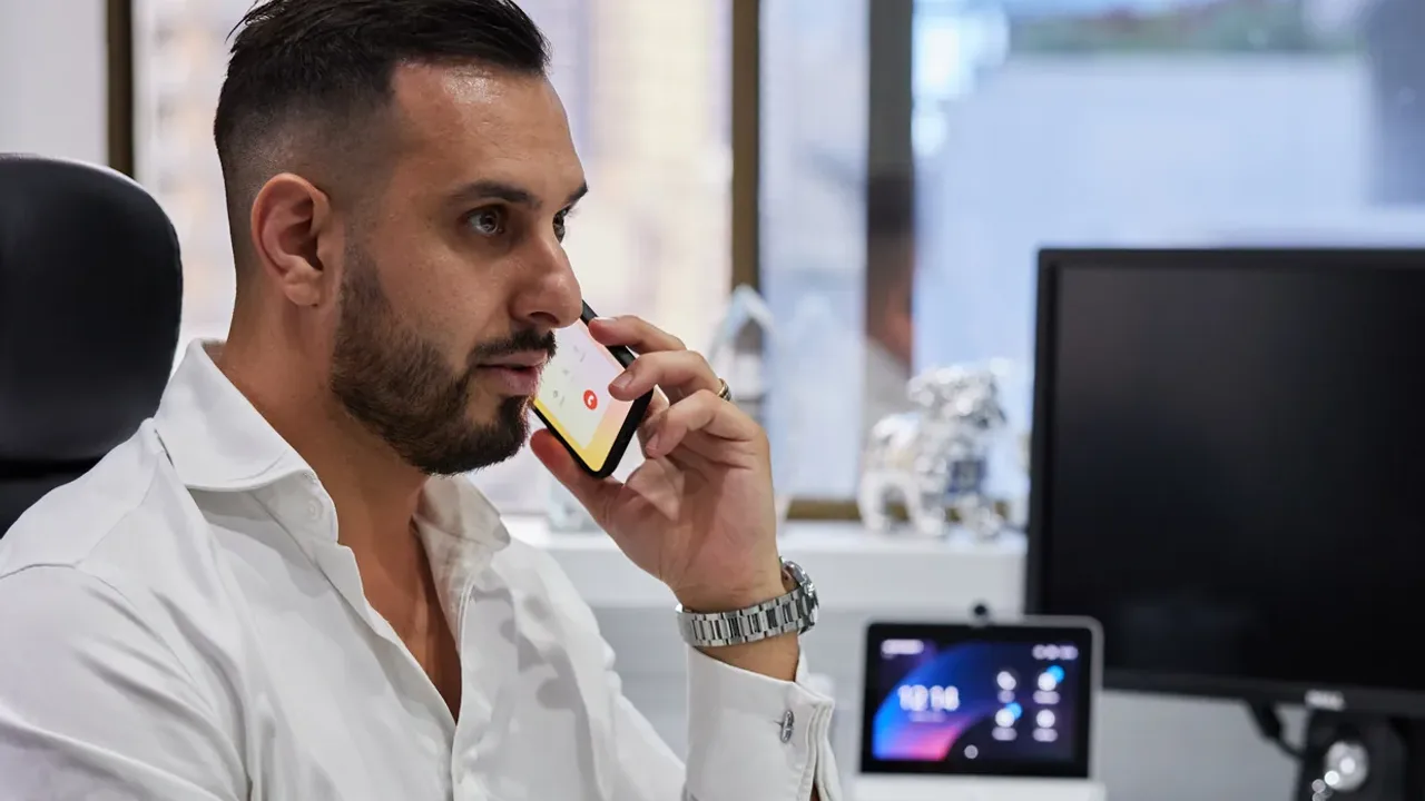 Business phone system for hybrid work: a man on a mobile at his desk